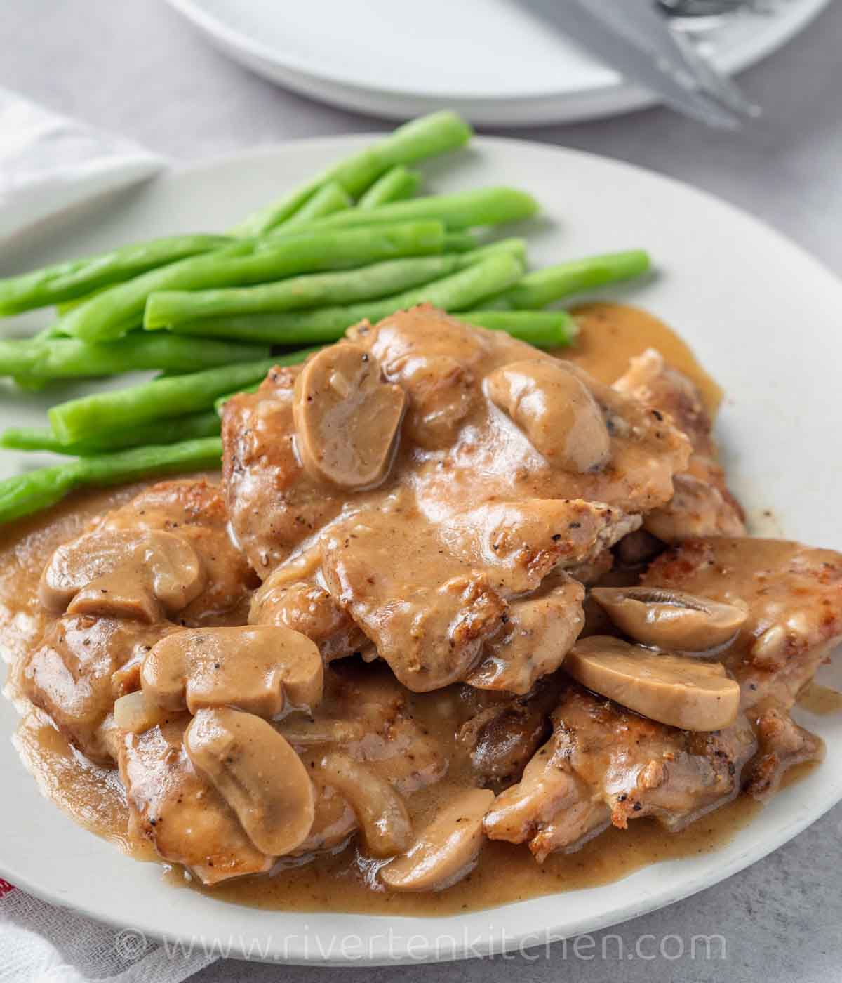 chicken thighs cooked in pan drizzled with homemade mushroom gravy.
