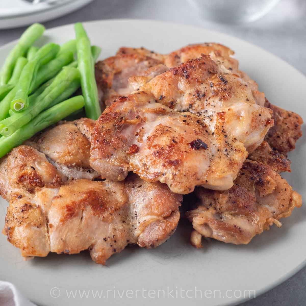 boneless, skinless chicken thighs pan-fried in a pan.