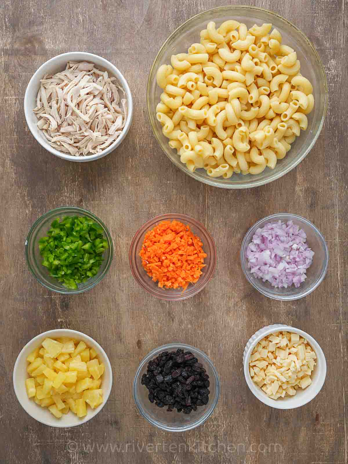 cooked macaroni, pineapple, cheese, raisins, carrots, bell pepper and shredded chicken.