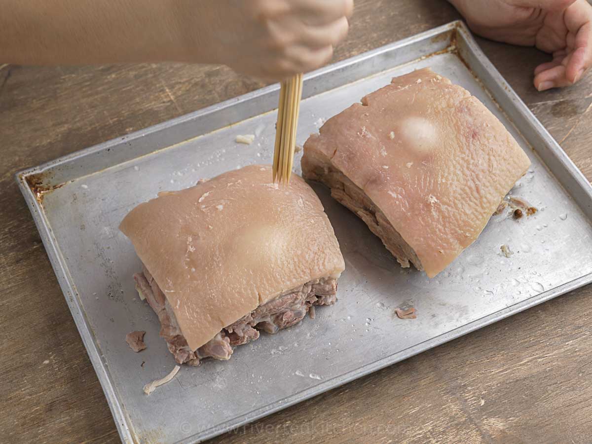 pork belly skin poked with small holes using skewers or fork.