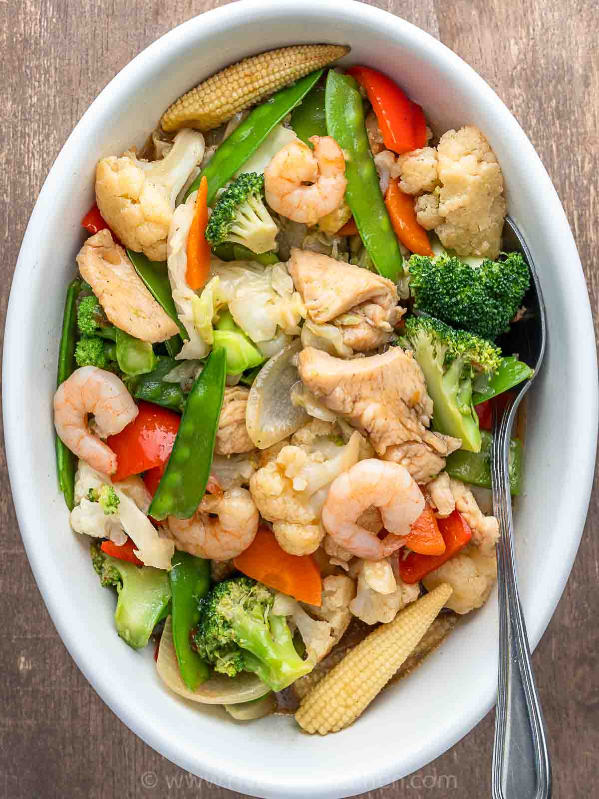 stir-fried vegetables with shrimp and chicken made with cabbage, baby corn, broccoli and cauliflower.