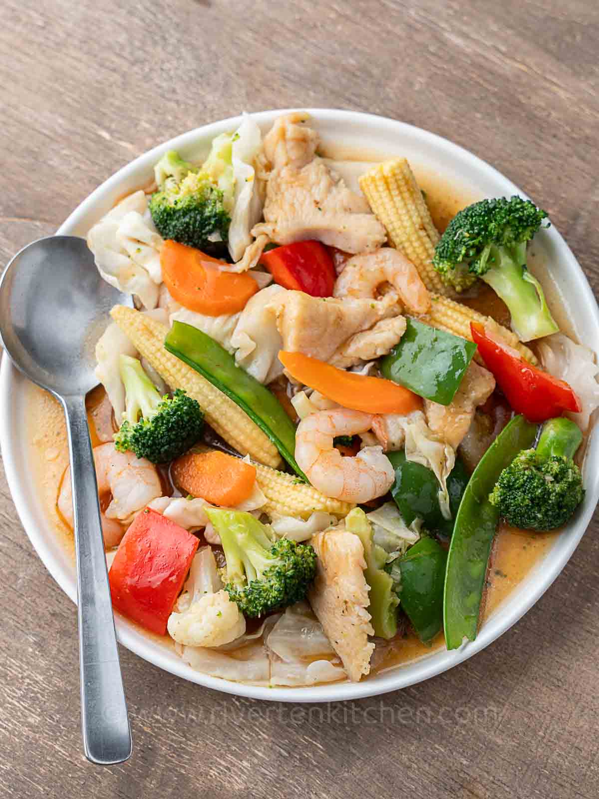 Filipino vegetable stir-fry called chop suey made with shrimp, chicken, cabbage, baby corn, broccoli, cauliflower and bell peppers.