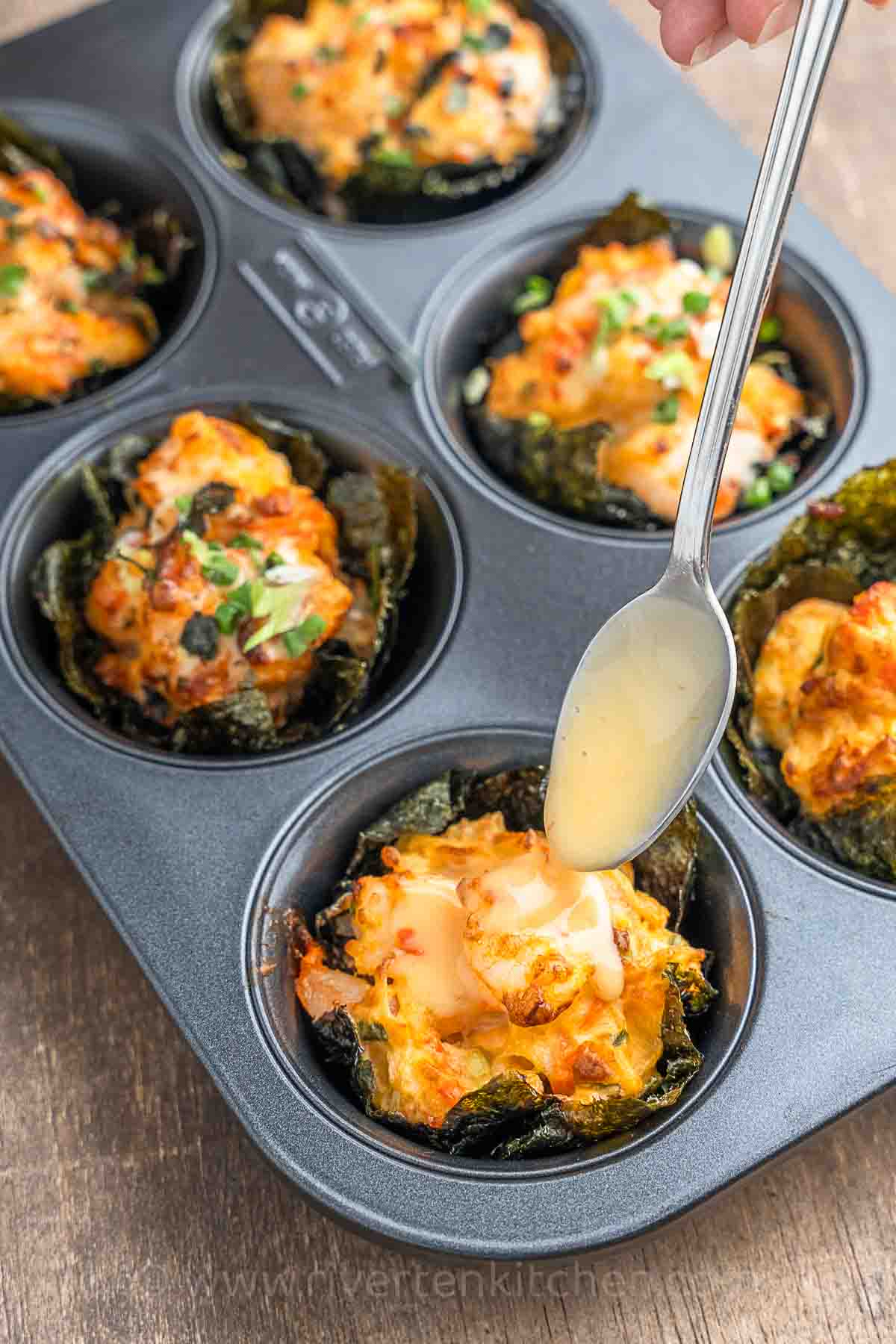 sushi bake cups with shrimp, imitation crab drizzled with sweet-chili and mayonnaise.