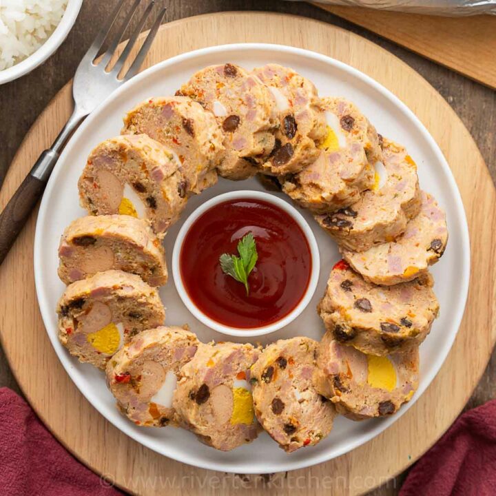 Filipino meatloaf served in a plate with ketchup dipping sauce.