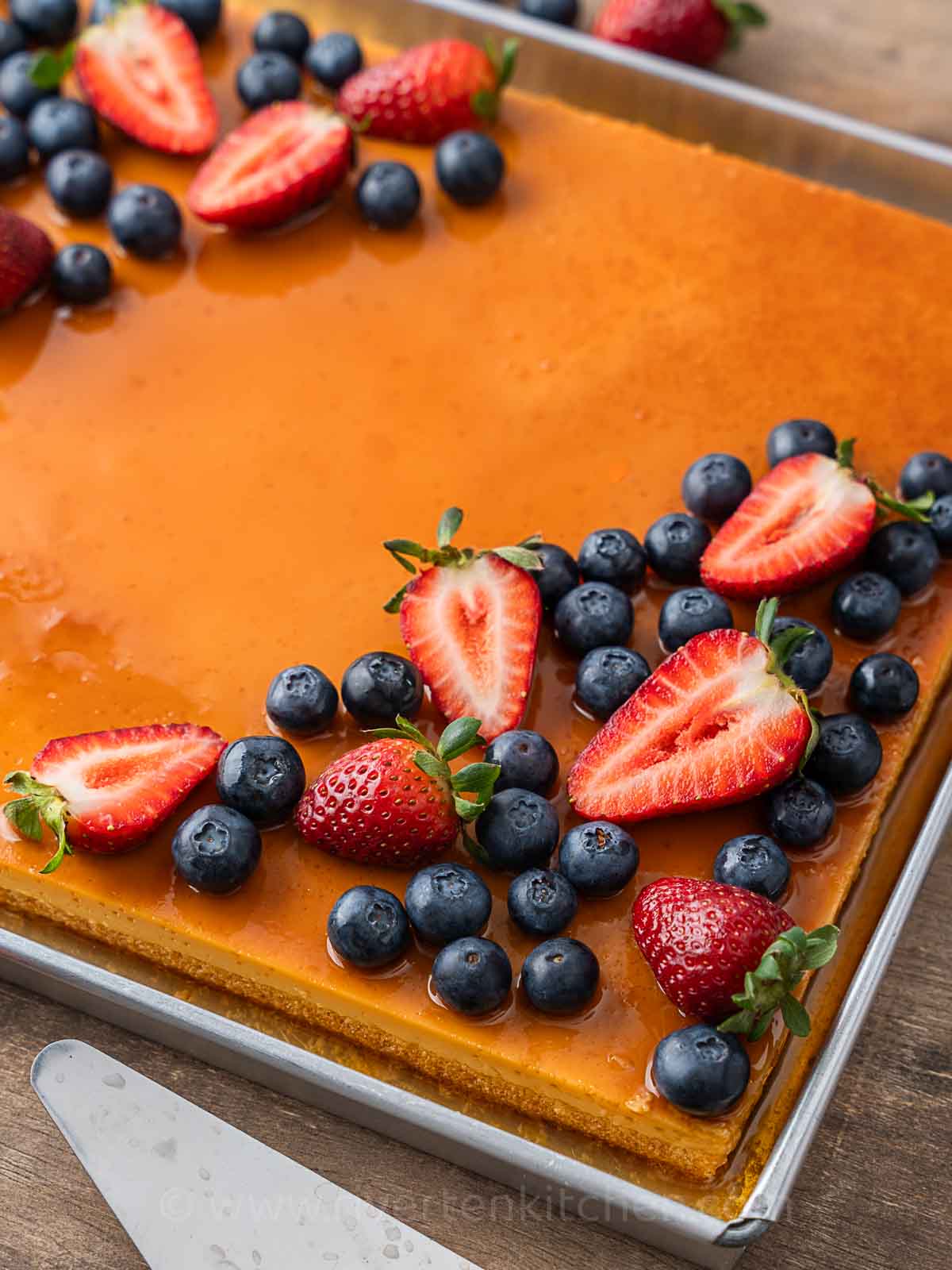 flan cake with strawberries and blueberries.
