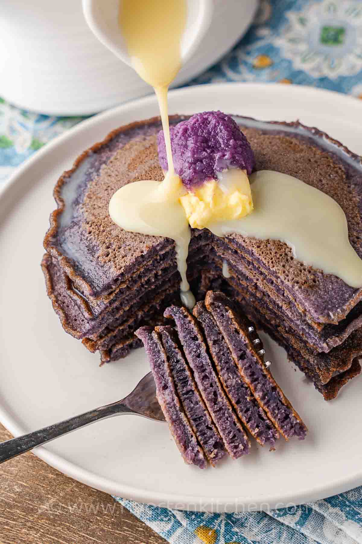 ube pancakes drizzled with condensed milk topped with butter and ube jam.