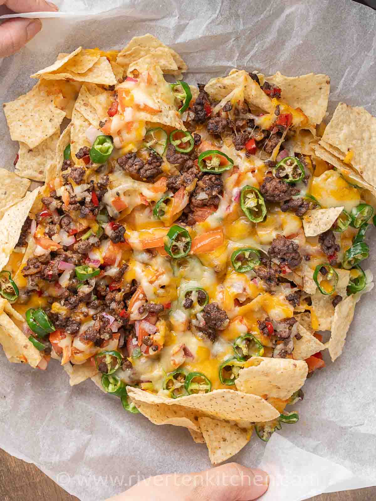 ground beef nachos with melted cheese, salsa, and jalapenos cooked in an air fryer.