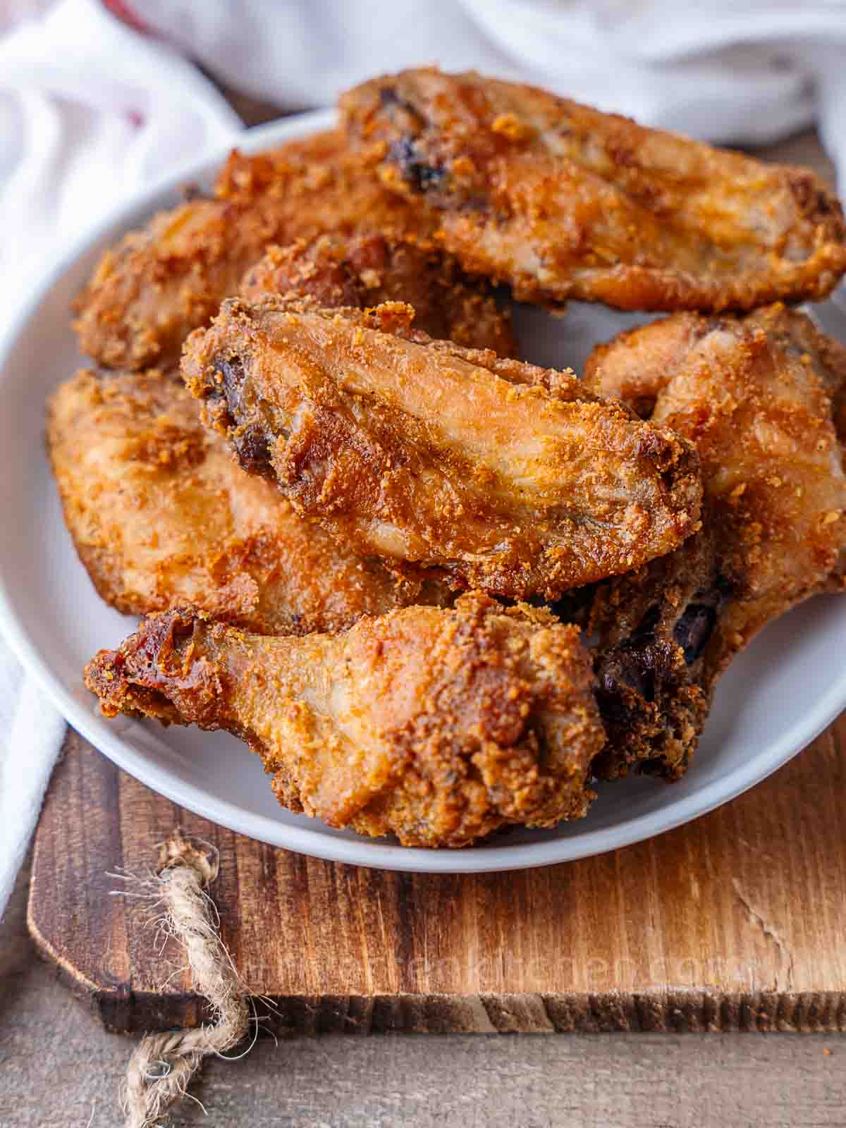 crispy chicken wings on a white plate.