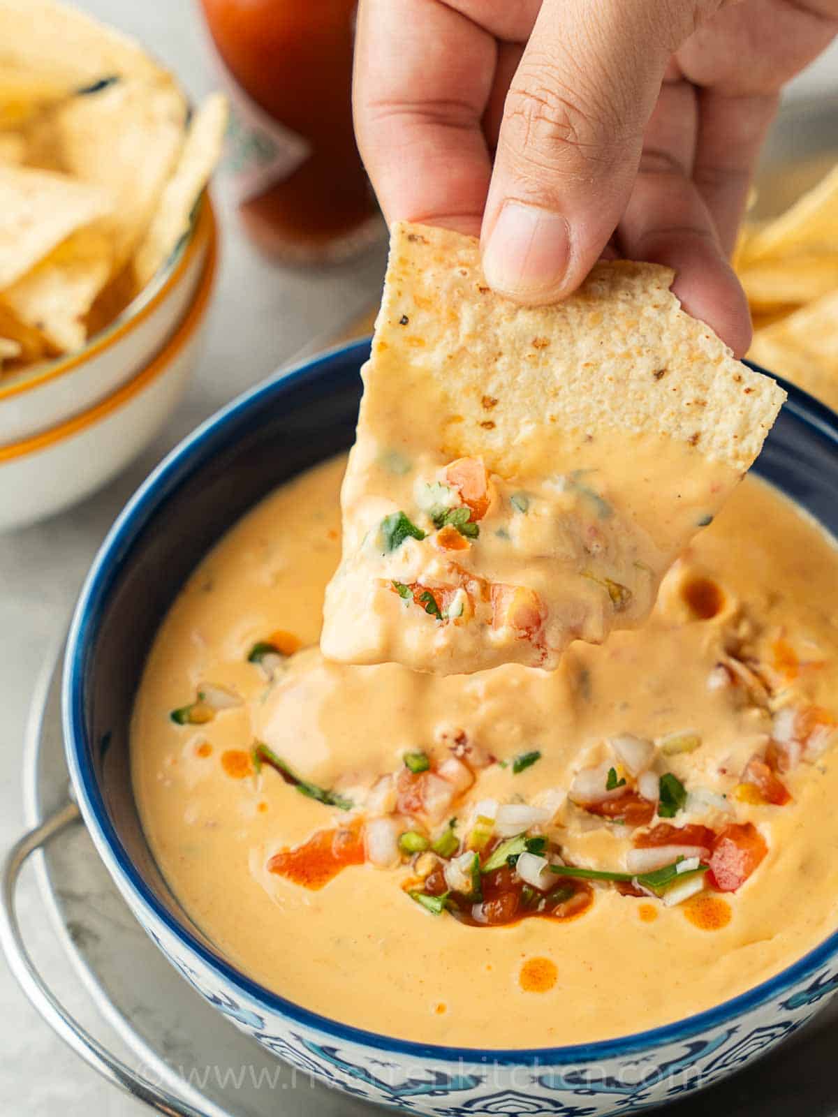 Cheese dip with salsa served in a bowl.