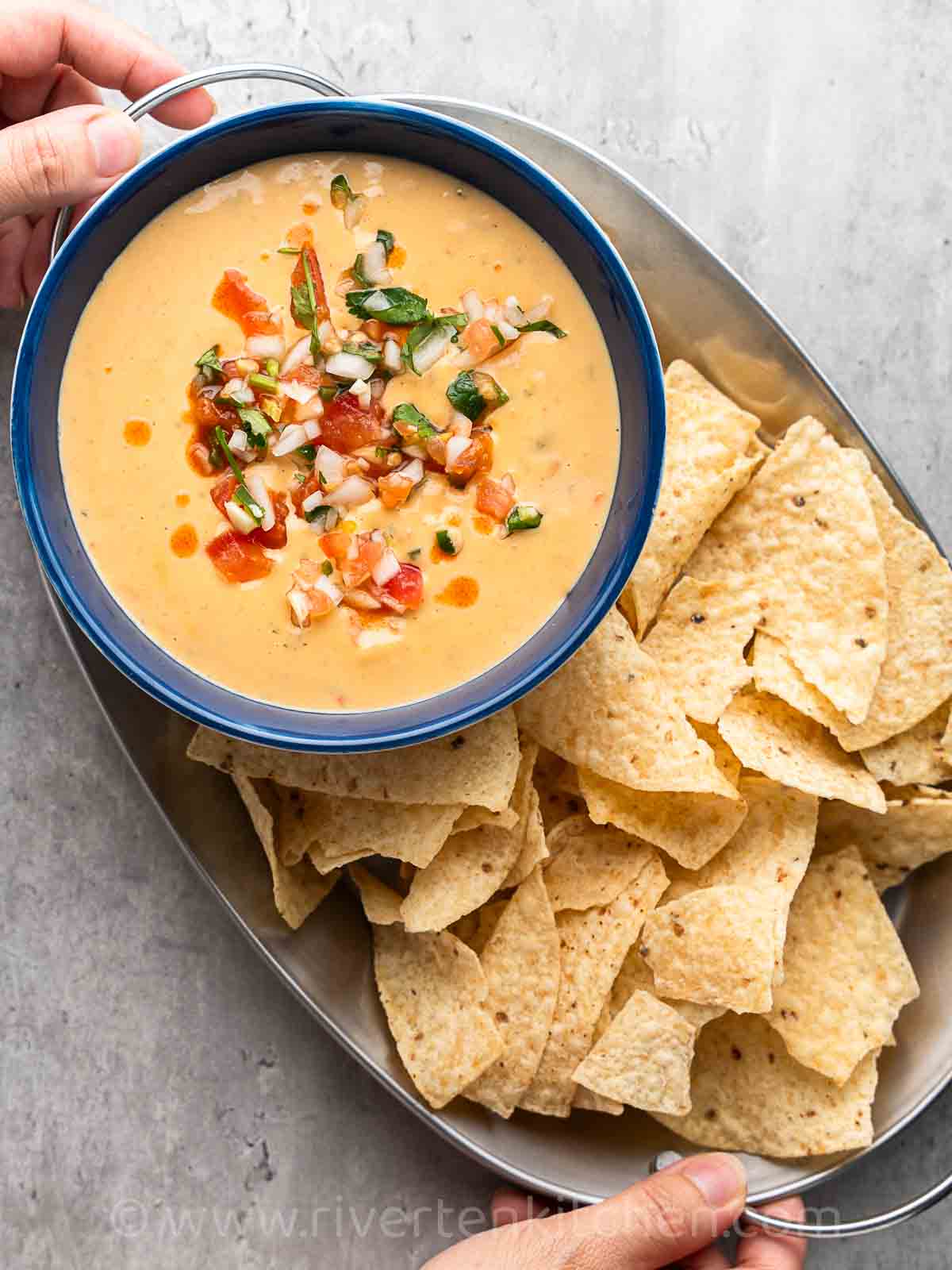 Nacho cheese sauce Mexican style served on a platter with nachos.