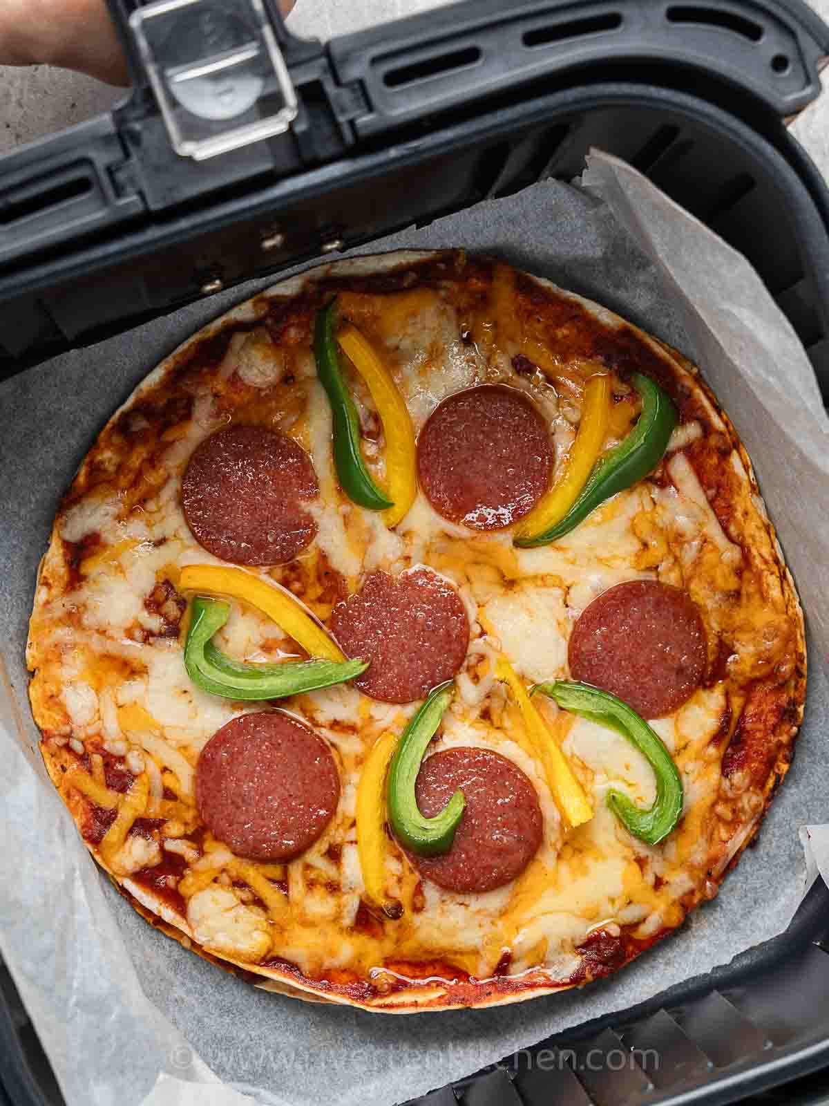 pizza made of tortilla wraps, bell pepper, cheese, and salami.
