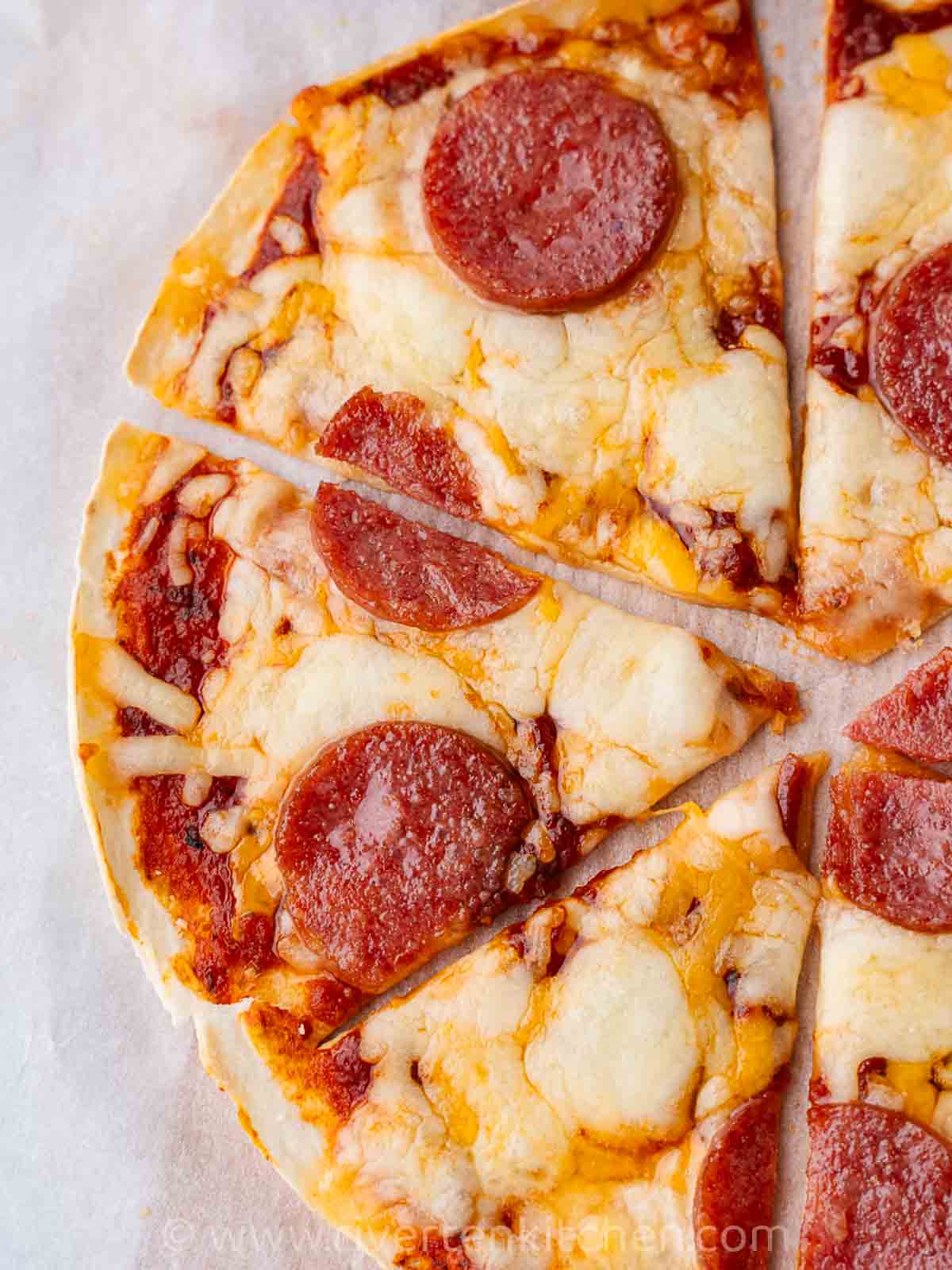 pizza made of tortilla, salami and cheese baked in an air fryer.